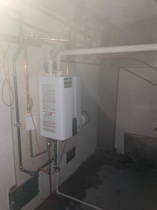 Removed existing conventional water heater and installed new wall-mounted tankless water heater unit in basement utility area. Completed all necessary plumbing connections including copper supply lines, PVC venting system, and associated shut-off valves to ensure proper operation and code compliance.
