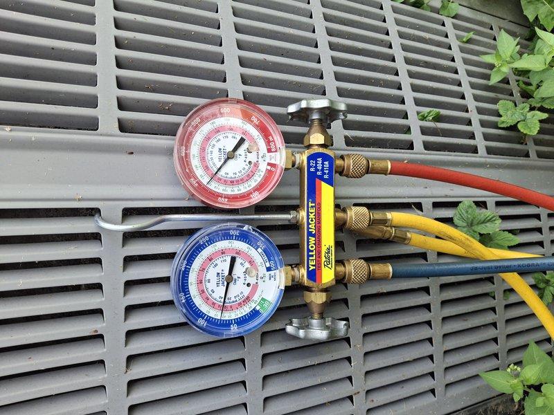 Completed annual maintenance on 13+ year old air conditioning system. Inspected condenser coil fins and found moderate dust accumulation; cleaned exterior surfaces to restore optimal airflow. Connected manifold gauge set to measure refrigerant pressures and verified system operating within manufacturer specifications across all parameters.