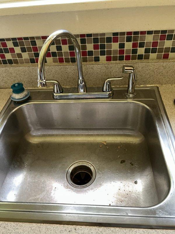 Responded to service call for non-functioning single-handle kitchen faucet in 75-year-old home. Upon inspection, diagnosed failed cartridge assembly in the chrome high-arc faucet unit. Removed and replaced defective cartridge, restored full water flow and handle operation. Tested hot and cold water supply lines, verified proper function of spray nozzle attachment, and confirmed no leaks at connections or base mounting. System returned to normal operating condition.