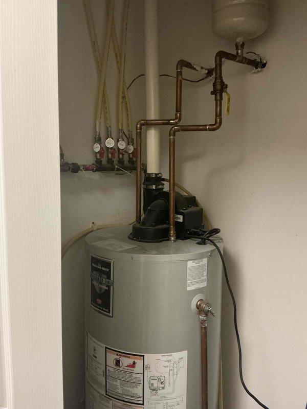 Conducted on-site estimate for replacement of 22-year-old residential water heater system. Documented existing installation including water heater tank, associated copper piping, circulation pump, expansion tank, pressure relief components, and manifold connections for assessment and replacement planning.