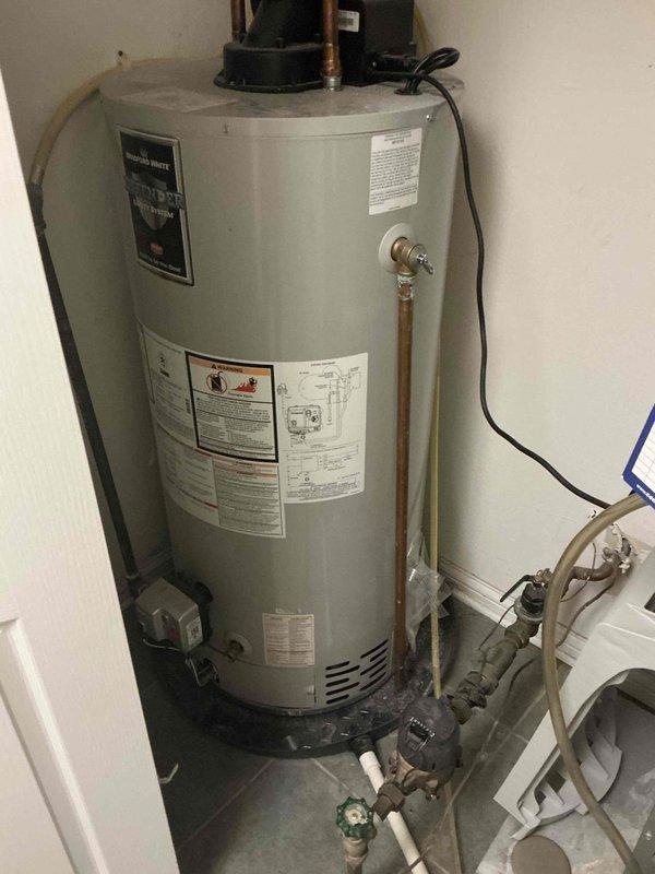 Conducted on-site estimate for replacement of 22-year-old residential water heater system. Documented existing installation including water heater tank, associated copper piping, circulation pump, expansion tank, pressure relief components, and manifold connections for assessment and replacement planning.