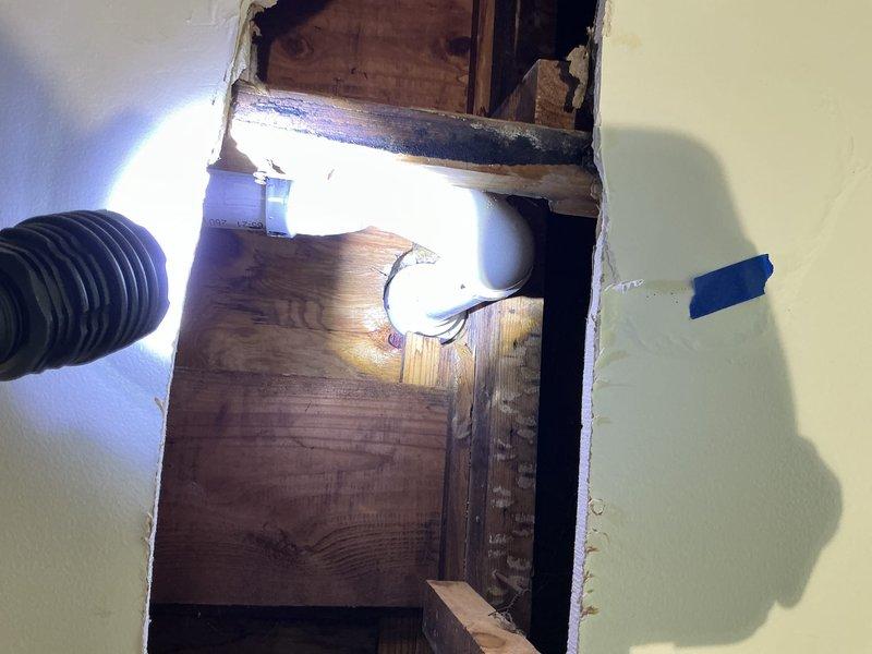 Accessed property using key left in mailbox as tenants were not home. Replaced defective shower strainer on second floor bathroom by opening ceiling from below to gain proper access to drain assembly. Cut access opening in drywall and plywood backing to reach shower pan drain connection. Moved insulation as needed to create working space. Removed old shower strainer from shower pan and disconnected from drain piping. Installed new shower strainer assembly and reconnected to drain piping with proper sealing. Tested installation for leaks and verified proper drainage operation. Protected kitchen area below work zone with floor coverings and appliance protection during overhead work to prevent damage from debris.