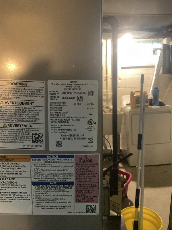 Responded to service call for air conditioning system over 10 years old not producing cold air despite fan operation. Upon inspection of the basement-installed HVAC system, conducted diagnostic evaluation of the cooling equipment and verified operational status of all major components including the furnace, evaporator coil assembly, and associated refrigerant lines. Documented equipment specifications and current system configuration with photographic evidence of unit labels, refrigerant information, and TXV components for service records.