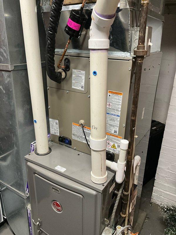 # HVAC Install - A/C & Coil

Completed full system replacement including outdoor condensing unit, indoor evaporator coil, and thermostat upgrade. Installed new Rheem condensing unit on existing concrete pad with proper clearances and secured electrical disconnect box. Connected refrigerant lines using copper piping and completed all necessary brazing connections. Mounted new evaporator coil to existing air handler in basement, ensuring proper integration with furnace system. Installed white PVC condensate drain lines with appropriate pitch for gravity drainage. Ran new electrical conduit from disconnect to outdoor unit and wired thermostat control system. Pressure tested refrigerant lines, evacuated system to manufacturer specifications, and charged unit with appropriate refrigerant per nameplate data. Verified all electrical connections, tested system operation through complete cooling cycle, and confirmed proper airflow and temperature differential across coil. All work completed to 