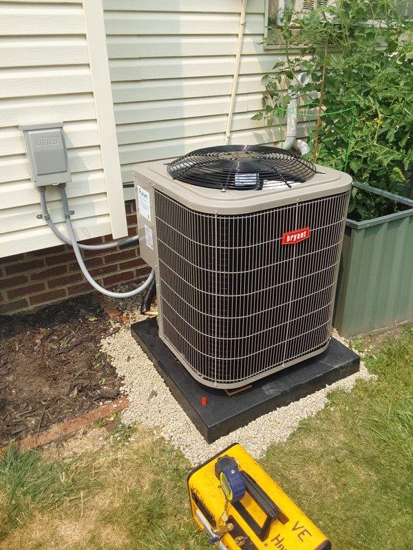 # HVAC Installation Summary

Completed full Bryant air conditioning system installation including outdoor condenser unit positioned on new rubber pad with gravel base, indoor evaporator coil, and programmable thermostat. Installed new electrical disconnect box with conduit, dedicated electrical circuit for AC system, and copper refrigerant lines connecting indoor and outdoor components. Modified ductwork system by enclosing previously open return air pathways to furnace with new metallic ductwork, properly secured with metal strapping to floor joists in basement area. System tested and operational upon completion.

---

## Detailed Work Performed

**Outdoor Unit Installation:**
Installed new Bryant condensing unit on dedicated black rubber equipment pad positioned on white gravel bed against exterior wall. Mounted gray electrical disconnect box to vinyl siding with appropriate conduit routing. Ran refrigerant line set from outdoor unit through wall penetration to connect with indoor co