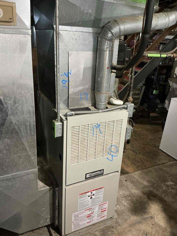 Conducted comprehensive on-site evaluation for complete HVAC system replacement in residential basement installation. Assessed existing Kenmore furnace unit and associated ductwork, documented current equipment configuration including air handler, plenum assembly, and galvanized metal ductwork with elbow connections. Photographed existing system components, mechanical room layout, and surrounding infrastructure to develop accurate replacement estimate for new furnace and air conditioning system.