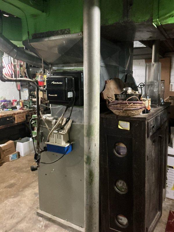 Conducted comprehensive on-site evaluation for complete HVAC system replacement in residential basement installation. Assessed existing Kenmore furnace unit and associated ductwork, documented current equipment configuration including air handler, plenum assembly, and galvanized metal ductwork with elbow connections. Photographed existing system components, mechanical room layout, and surrounding infrastructure to develop accurate replacement estimate for new furnace and air conditioning system.