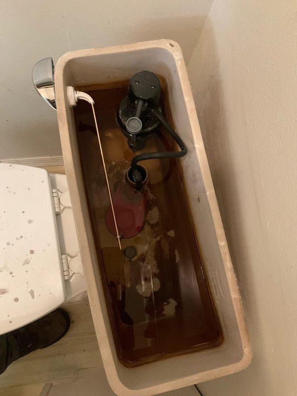 Responded to service call for broken toilet handle and internal tank leakage. Upon inspection, removed tank lid and found severely discolored water with heavy rust and mineral deposits throughout tank interior. Assessed flush mechanism components including deteriorated flapper, flush valve assembly, and fill valve system. Replaced faulty flush handle assembly and installed new flapper to eliminate continuous water leak into bowl. Addressed internal tank staining caused by mineral buildup and corrosion. Tested flush operation to ensure proper handle function and complete water shutoff between flush cycles, restoring normal toilet operation.