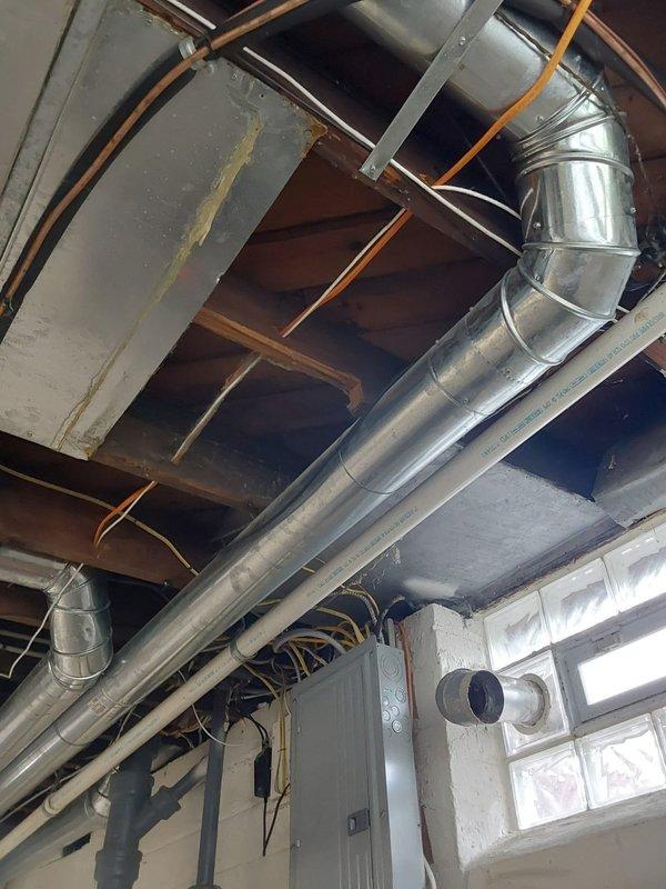 Completed full HVAC system replacement including installation of new Bryant 97% high efficiency gas furnace with single stage heating and multi-speed ECM blower motor. Installed new Bryant air conditioning system with outdoor condenser unit, indoor evaporator coil, concrete condenser pad, and electrical disconnect box. Ran new metallic ductwork through ceiling joists to accommodate system airflow requirements. Mounted condenser unit on pad against exterior wall with proper electrical connections and conduit routing. Existing thermostat was retained and reconnected to new equipment. All components tested and verified operational upon completion.