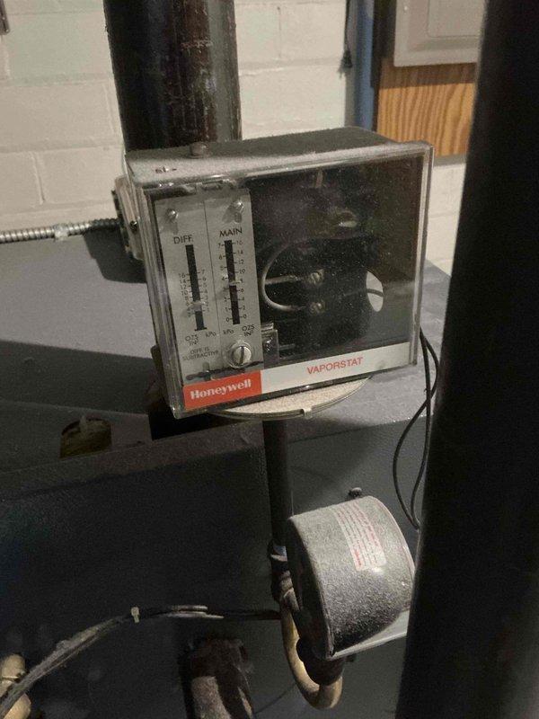 Conducted comprehensive assessment of existing HVAC system for equipment replacement estimate. Air conditioning unit failing to maintain adequate cooling capacity during operation. Boiler system inspection revealed corrosion on components and piping, indicating deterioration that compromises system integrity and efficiency. Documented existing equipment conditions including Honeywell Vaporstat steam pressure control, corroded piping at base of mechanical equipment, and condensate drain lines showing age-related wear. Photographed current system configuration and equipment deficiencies to support replacement recommendations for both heating and cooling systems.