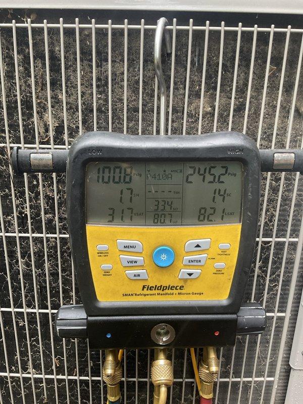 Completed return trip to system requiring additional technician support. Performed refrigerant system diagnostics using digital manifold gauges, recording operating pressures and temperatures. Left side pressure reading 100.6 PSI, right side pressure 245.2 PSI, with superheat at 14°F and subcooling at 82°F indicated on equipment. Monitored system performance parameters during severe weather conditions including heavy thunderstorms with temperatures in low 80s and high humidity levels at 94%.