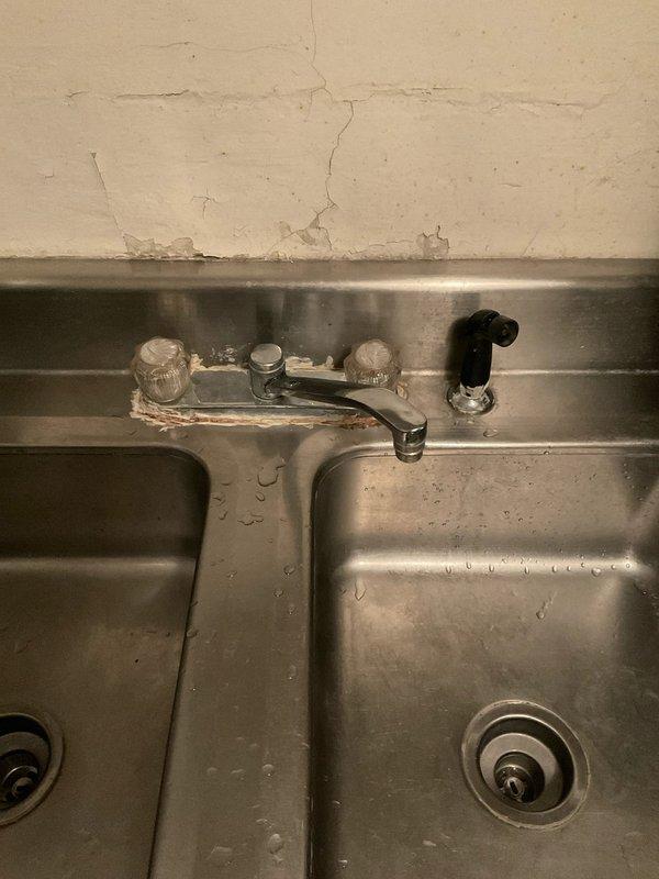 Conducted site assessment for upcoming kitchen faucet replacement on commercial-grade stainless steel double-basin sink. Confirmed existing wall-mounted faucet configuration with two-handle setup and spray attachment requires replacement with customer-supplied fixture compatible with current three-hole mounting arrangement. Documented existing plumbing setup and verified sink compatibility for future installation appointment once new faucet unit is available on-site.
