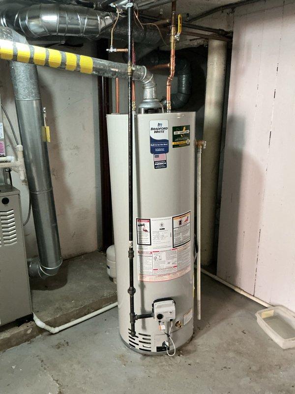Responded to service call for leaking 40-gallon Bradford White residential water heater located in basement utility space. Upon inspection, identified active leak requiring unit replacement. Disconnected existing water heater from copper supply lines, gas line, and exhaust flue system. Removed failed unit and installed new 40-gallon water heater with proper venting configuration. Connected hot and cold water copper piping with appropriate brass fittings, installed pressure relief valve with discharge pipe, and reconnected gas supply line to burner assembly. Tested all connections for leaks, verified proper gas combustion, and confirmed temperature and pressure relief valve operation. System restored to full working condition.