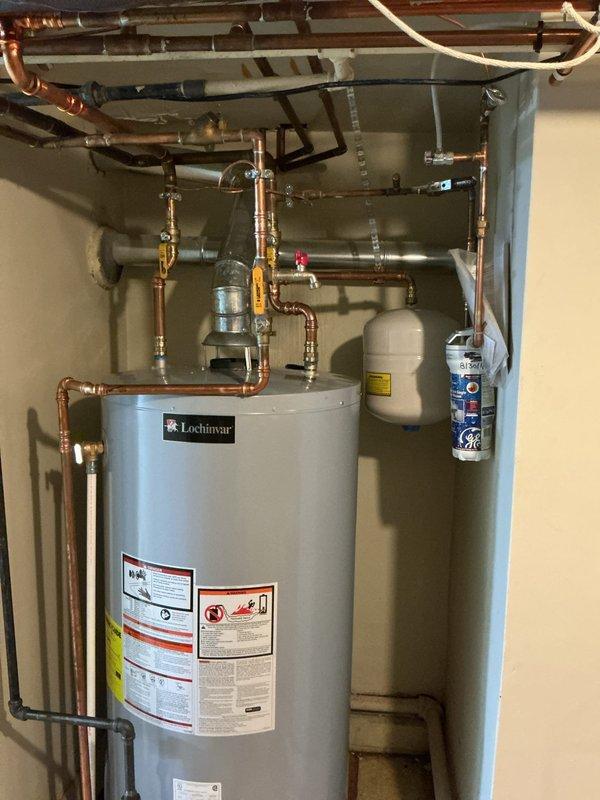 Replaced 75-gallon Lochinvar water heater under warranty with complete reconnection of copper supply and distribution piping, including installation of expansion tank, circulation pump, and associated valves and fittings. Repaired burst pipe in pool room area with new copper piping sections and proper soldered connections to restore water flow and prevent further water damage.