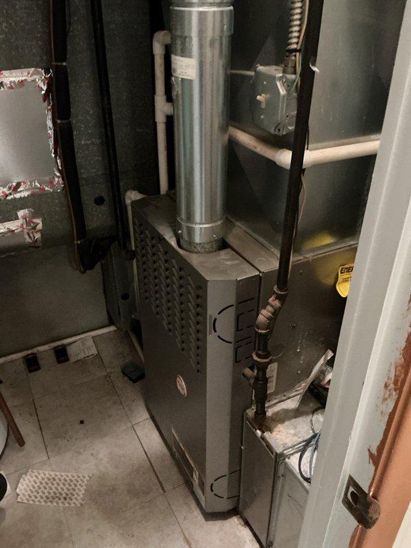 Performed comprehensive cooling system maintenance on a twenty-year-old air conditioning unit that was operating properly at time of service. Conducted standard AC tune-up procedures including system inspection, performance verification, and documentation of existing equipment condition. Photographed basement-mounted furnace installation and associated mechanical components for service records.
