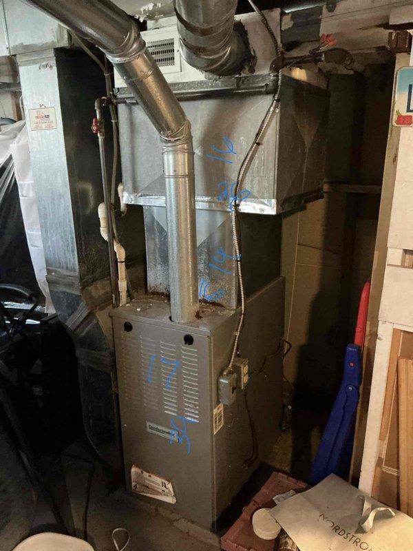 Conducted on-site evaluation for add-on air conditioning system installation to existing forced-air heating setup. Assessed current furnace unit located in basement utility area, documenting equipment specifications and ductwork configuration for compatibility with proposed cooling system. Examined existing supply and return ductwork extending from furnace unit to determine adequate sizing and structural integrity for AC integration. Evaluated outdoor placement options for condensing unit, inspecting exterior wall area and existing utility conduit routing. Photographed current HVAC equipment and proposed outdoor installation location to prepare comprehensive replacement estimate for complete heating and cooling system.