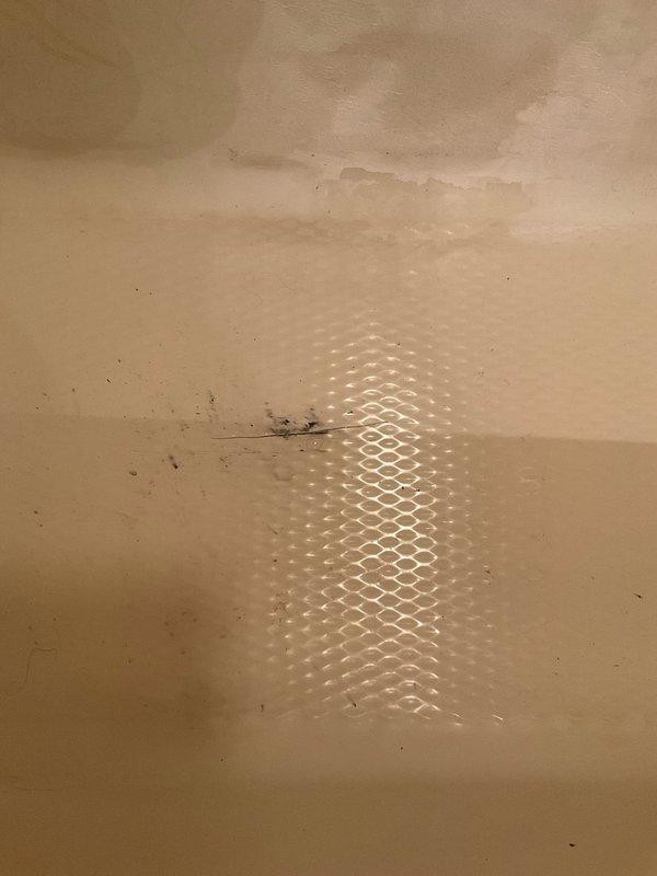 Responded to emergency call for bathtub drain malfunction causing water leak through ceiling below. Upon inspection, identified clogged drain assembly with corroded stopper mechanism preventing proper water drainage. Cleared obstruction, tested drain flow, and verified no further water penetration to lower level ceiling, resolving the immediate leak issue.