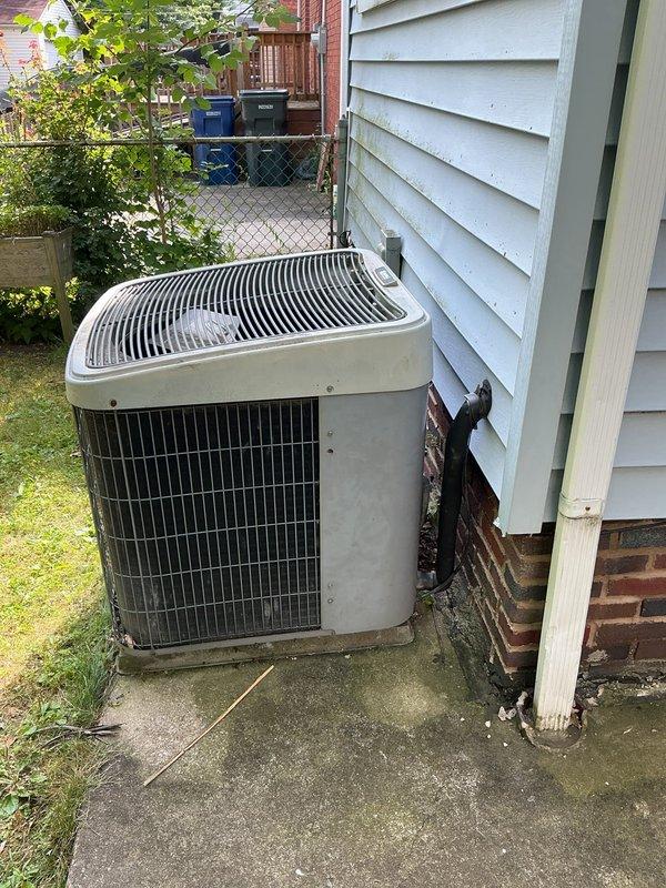 Arrived on-site to assess existing outdoor condensing unit for replacement estimate. Customer requested verbal ballpark pricing prior to formal estimate presentation. Documented current system condition with photos showing aged unit with weathering and discoloration, positioned on concrete pad with cracked surface adjacent to residence exterior.