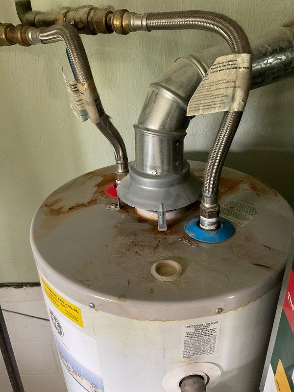 Conducted free estimate for natural gas water heater replacement. Inspected existing tanked water heater showing visible signs of age, corrosion, and rust accumulation on top surface and around fittings. Assessed current installation configuration including flexible braided stainless steel supply lines, copper piping connections, and pressure relief valve assembly. Evaluated electrical panel to confirm proper circuit availability and capacity for new unit installation. Documented existing conditions through photographs for replacement proposal and provided customer with equipment options and installation recommendations.
