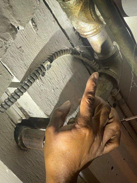 Responded to gas leak emergency at multi-unit property with three separate leak locations identified by gas utility company. Performed comprehensive system inspection and air pressure test on natural gas lines to verify integrity and locate all leak points. Inspected exposed gas piping, connections, and shutoff valves in utility area, documented conditions with photographs, and assessed pipe fittings and flexible connectors for proper sealing and code compliance.