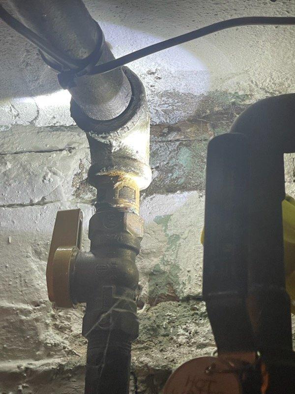 Responded to gas leak emergency at multi-unit property with three separate leak locations identified by gas utility company. Performed comprehensive system inspection and air pressure test on natural gas lines to verify integrity and locate all leak points. Inspected exposed gas piping, connections, and shutoff valves in utility area, documented conditions with photographs, and assessed pipe fittings and flexible connectors for proper sealing and code compliance.