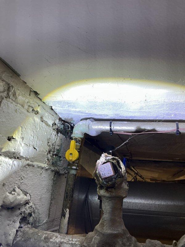 Responded to gas leak emergency at residential property where utility company identified three separate leak locations. Conducted comprehensive gas line pressure test of entire system, inspecting all exposed piping, valves, and connections in basement utility area. Located and repaired multiple leak points on aged natural gas distribution system, tested all repairs to ensure system integrity and safe operation, and documented conditions with photographic evidence of gas meter assembly and overhead piping configuration.