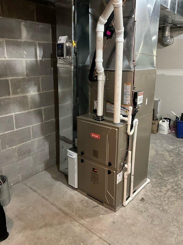 Completed full Bryant HVAC system installation including outdoor condensing unit positioned on new pad against exterior foundation wall, indoor evaporator coil integrated with existing furnace in basement mechanical room, new copper refrigerant line set connecting indoor and outdoor components, and new electrical disconnect box mounted to exterior wall. All refrigerant lines were properly insulated and secured along building exterior using appropriate fastening methods. System was charged to manufacturer specifications, tested for proper operation across all modes, and verified for correct airflow and temperature differential. Existing thermostat was retained and confirmed compatible with new equipment. Installation meets all applicable codes and manufacturer requirements for warranty compliance.