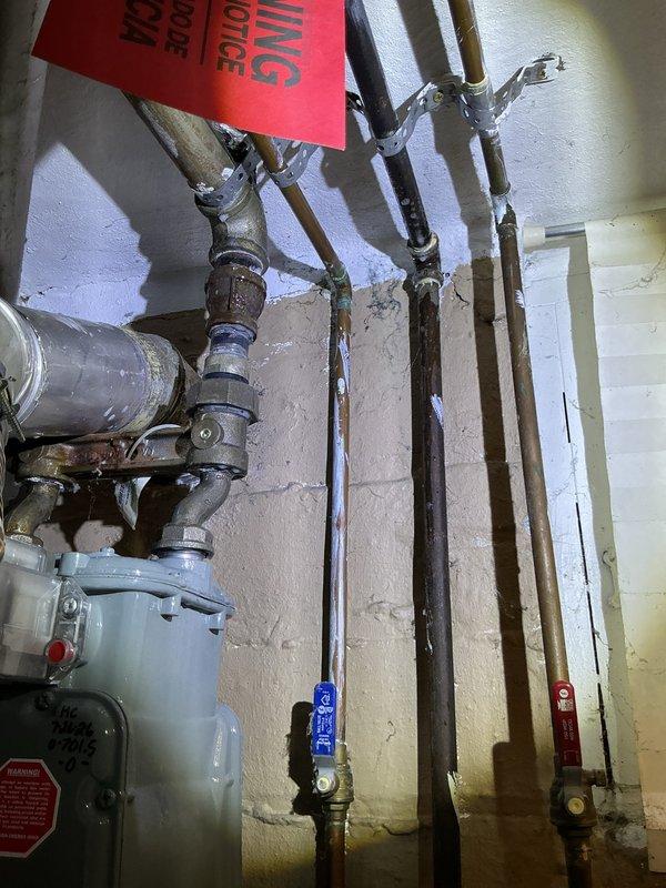 Responded to gas leak at dryer connection line over two consecutive service visits. Initial repair attempt on first visit did not resolve the issue. Returned for follow-up service where gas utility company confirmed active leak persisting at dryer gas line connection point. Documented conditions with photographs showing utility area infrastructure and plumbing systems. Coordinated access procedures and obtained necessary approvals prior to proceeding with repairs.