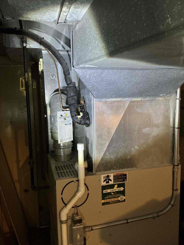 Responded to service call for non-operational air conditioning system. Upon inspection of the basement mechanical space, evaluated the existing HVAC equipment including the furnace unit, associated ductwork, and refrigerant lines. Documented the current system configuration with photographs showing the furnace installation, water heater proximity, copper refrigerant piping with insulation, metallic flexible ductwork, and overall mechanical room layout. Assessed equipment condition and prepared comprehensive replacement estimate for new air conditioning system to restore cooling functionality to the residence.