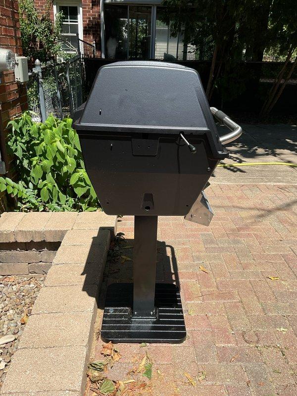 Completed outdoor grill assembly and connected unit to existing gas line infrastructure. Installed copper piping with shut-off valve and flexible gas connector, properly secured with mounting brackets along wall and ceiling junction to supply gas to exterior patio location. Grill positioned on brick paver patio and successfully connected to gas supply line, with all connections tested for proper operation and safety.