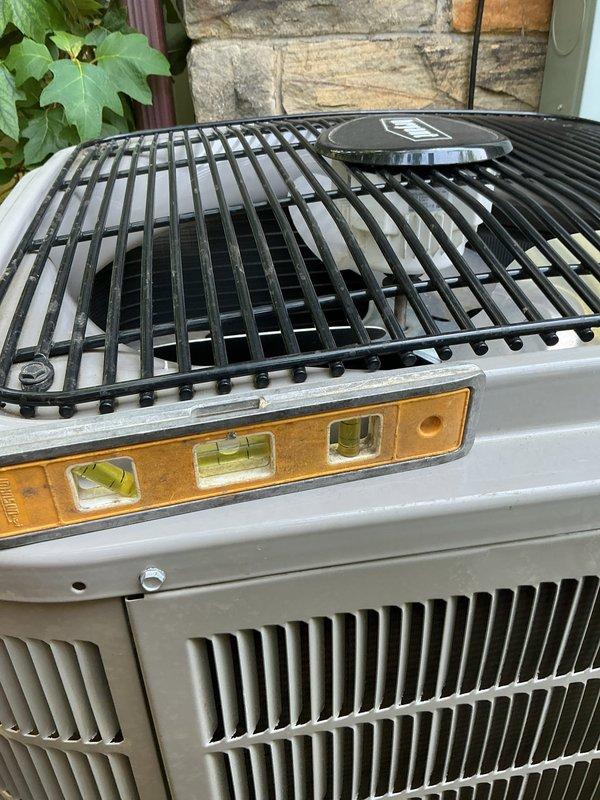 Leveled Bryant condenser unit to manufacturer specifications to prevent compressor damage and oil migration issues. Unit was found to be improperly positioned on pad, creating potential for premature equipment failure. Adjusted and stabilized condenser on concrete pad using proper leveling techniques, verified alignment with precision level tool to ensure optimal refrigerant flow and compressor longevity.