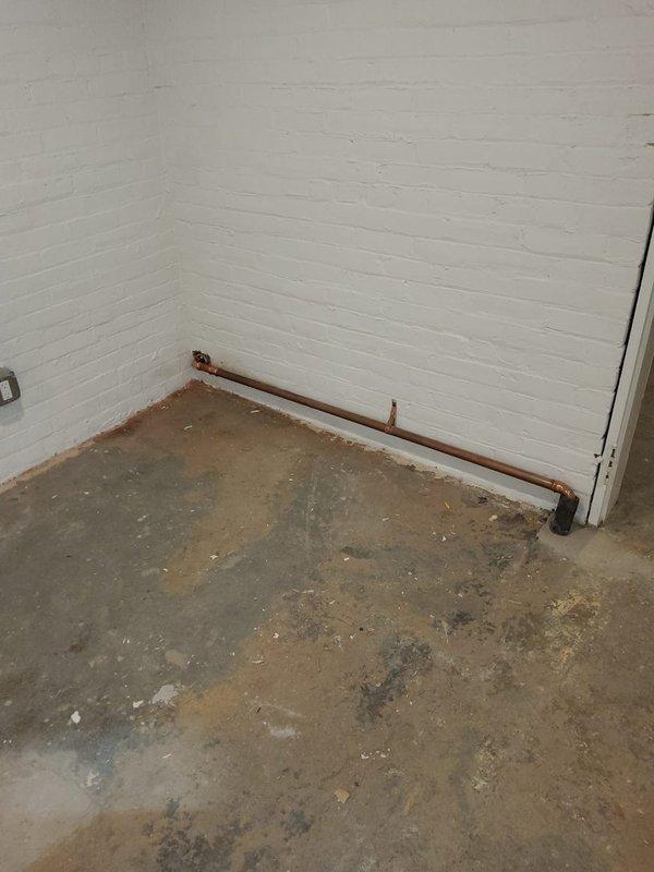 Replaced stolen wet return piping in basement steam heating system using copper pipe with proper pitch for condensate drainage. Installed 14 new radiator valves throughout the building to restore system functionality and ensure proper steam distribution and condensate return to the boiler.