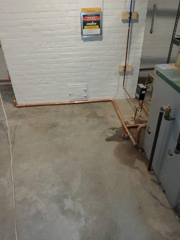 Replaced stolen wet return piping in basement steam heating system using copper pipe with proper pitch for condensate drainage. Installed 14 new radiator valves throughout the building to restore system functionality and ensure proper steam distribution and condensate return to the boiler.