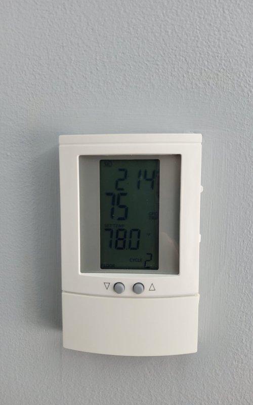 Responded to service call for radiant floor heating system with non-functional thermostat. Evaluated existing wall-mounted digital thermostat displaying temperature readings and verified control compatibility with floor heating system. Documented thermostat configuration and control panel settings for proper system operation.