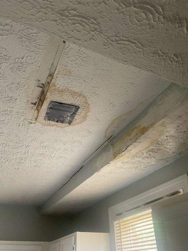 Responded to ceiling leak originating from bathroom plumbing in century-old residential structure. Accessed affected area through ceiling hatch to identify source of water intrusion causing visible staining on textured ceiling surface. Inspected basement plumbing connections and HVAC system drainage lines for potential leak points. Documented water damage patterns and equipment configuration for repair assessment. Customer also requested separate HVAC cooling system consultation to be scheduled.