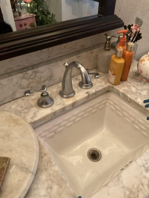 Installed a chrome two-handle widespread lavatory faucet with pop-up drain assembly on existing marble vanity countertop. Provided and installed a Gerber Avalanche elongated toilet with matching seat, new wax ring seal, and supply line to complete the bathroom fixture upgrades.