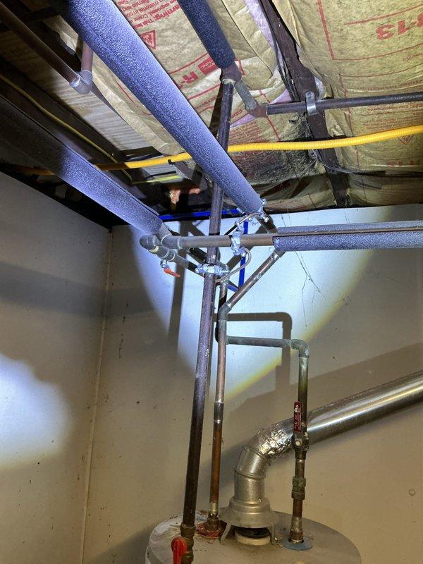 Performed on-site assessment of reported leaking pipe associated with existing tank-style water heater in basement utility area. Documented current plumbing configuration including copper supply lines, shut-off valves, and connections to determine source of leak and provided estimate for repair options including conventional water heater replacement or tankless system installation.