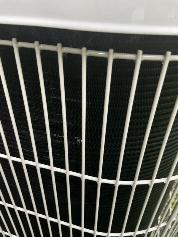 Performed basic condenser coil cleaning on outdoor air conditioning unit without removal of side panels or condenser fan. Unit was serviced in place with coils cleaned through protective wire guard, maintaining equipment integrity while removing debris and buildup to restore proper airflow and heat exchange efficiency.