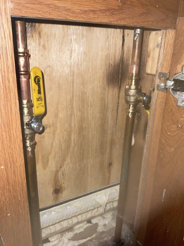 Installed two 1/2-inch ball shut-off valves on copper supply lines located within an access cabinet. The valves were positioned on vertical risers serving the bathroom plumbing fixtures, providing individual isolation capability for maintenance and emergency shutoff purposes.