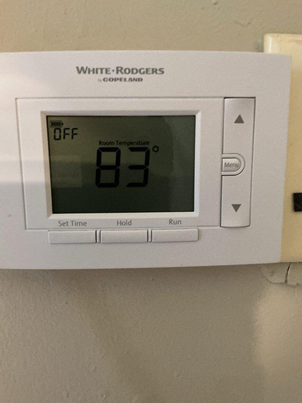 Met with inspector on-site at approximately noon as scheduled to facilitate HVAC system inspection. Documented existing White-Rodgers by Copeland digital programmable thermostat installation with photographs showing unit in OFF mode with room temperature reading of 83°F, capturing both mounted and detailed views of the control interface and display for inspection records.