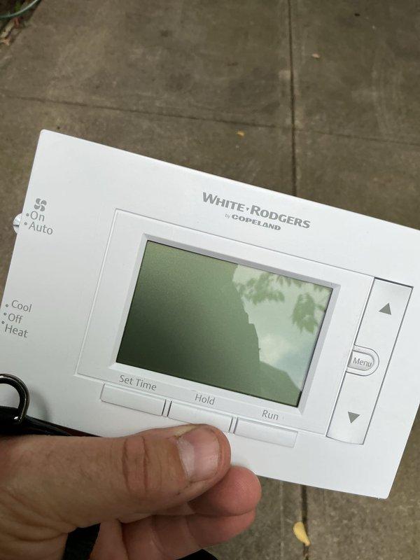 Met with inspector on-site at approximately noon as scheduled to facilitate HVAC system inspection. Documented existing White-Rodgers by Copeland digital programmable thermostat installation with photographs showing unit in OFF mode with room temperature reading of 83°F, capturing both mounted and detailed views of the control interface and display for inspection records.