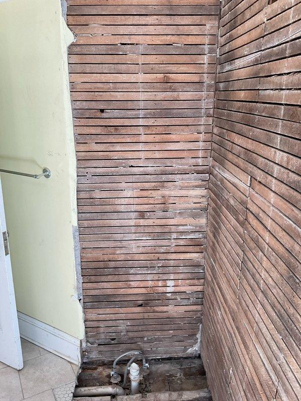 Completed rough-in installation of drain and water supply lines for shower in basement area. Performed necessary demolition work to access plumbing pathways through existing wooden stairwell structure and adjacent walls. Restored functional shower plumbing system to property that previously had no working shower facilities.