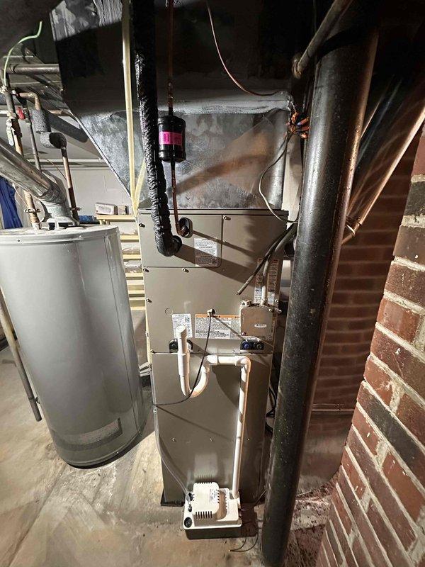 Completed full HVAC system replacement in basement utility area, including new furnace installation with matching evaporator coil, outdoor air conditioning unit, and Ecobee smart thermostat. All equipment properly positioned and secured with ductwork connections completed to existing infrastructure. System tested and verified operational with proper airflow and temperature control functionality.