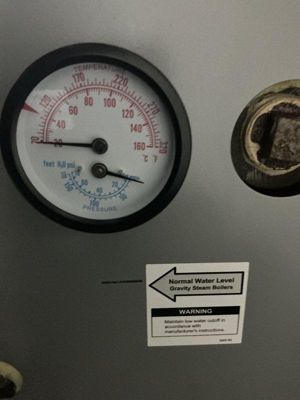 Relocated steam supply and return piping in exposed floor cavity, installed new white PVC drainage lines with proper elbow connections through wooden joist framework. System was filled and pressure tested using boiler gauge monitoring to verify no leaks were present, then all accessible piping was insulated per code requirements.