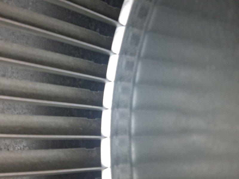 Performed routine cooling maintenance on outdoor condensing unit. Inspected condenser coil fins, noting normal dust accumulation and operational wear. Measured and recorded discharge air temperature at 106.5°F, confirming system operating within normal parameters. Unit found in satisfactory working condition with no immediate repairs required.