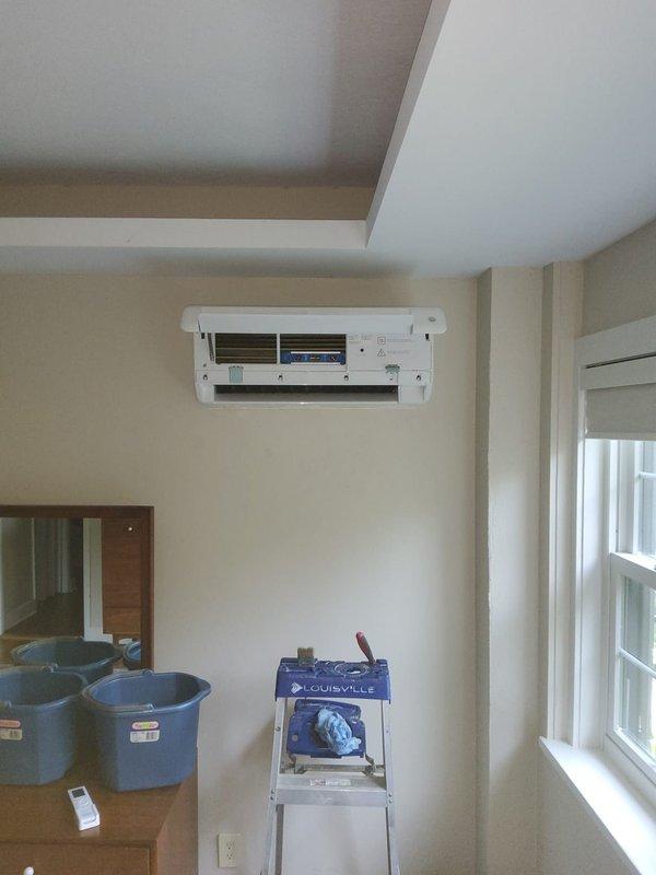 Responded to service call for water leak from 2-year-old mini-split air conditioning unit. Upon arrival, accessed the indoor wall-mounted evaporator unit and opened the front cover to inspect internal components. Discovered condensate drainage issue causing water leakage. Removed and cleaned the air filter and inspected the evaporator coil fins, which showed accumulation requiring attention. Examined the condensate drain line and drain pan for blockages or improper drainage. Cleared obstruction from drain line and verified proper water flow. Performed preventative maintenance including cleaning of heat exchanger fins and checking refrigerant line connections at the blue header assembly. Tested unit operation to confirm leak was resolved and system was functioning properly with no further water discharge. Unit returned to normal operation with proper condensate drainage restored.