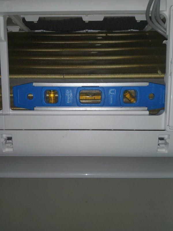 Responded to service call for water leak from 2-year-old mini-split air conditioning unit. Upon arrival, accessed the indoor wall-mounted evaporator unit and opened the front cover to inspect internal components. Discovered condensate drainage issue causing water leakage. Removed and cleaned the air filter and inspected the evaporator coil fins, which showed accumulation requiring attention. Examined the condensate drain line and drain pan for blockages or improper drainage. Cleared obstruction from drain line and verified proper water flow. Performed preventative maintenance including cleaning of heat exchanger fins and checking refrigerant line connections at the blue header assembly. Tested unit operation to confirm leak was resolved and system was functioning properly with no further water discharge. Unit returned to normal operation with proper condensate drainage restored.