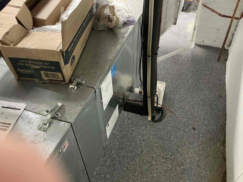 Completed HVAC equipment estimate for potential Unico system installation in basement mechanical room. Assessed existing gray HVAC unit and surrounding infrastructure including ductwork with reflective insulation, copper piping, electrical panel, and air quality equipment. Documented current system configuration and available space for proposed high-velocity air conditioning system replacement.