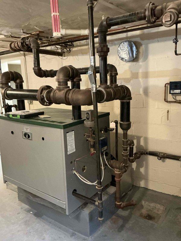 Conducted on-site assessment of existing steam boiler system for replacement estimate. Inspected current boiler unit, associated black iron piping network, and distribution system configuration. Evaluated condition of aging equipment, existing ductwork showing accumulated dust and grime, and overall mechanical room layout to determine scope of replacement work and compatibility requirements for new equipment installation.