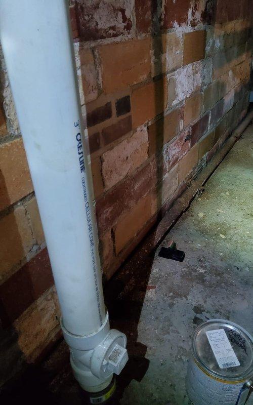 Responded to service call for mini split AC system with undetermined issue. Upon arrival, performed diagnostic inspection of outdoor unit and associated refrigerant lines. Inspected copper refrigerant piping connections showing signs of age with visible oxidation and patina buildup. Examined compression fittings connecting copper lines to flexible refrigerant hoses, noting dust accumulation on line insulation. Checked mechanical connections in basement/crawl space area where refrigerant lines enter structure. All connections found secure with no visible refrigerant leaks detected. System components inspected and documented via photography for service records.